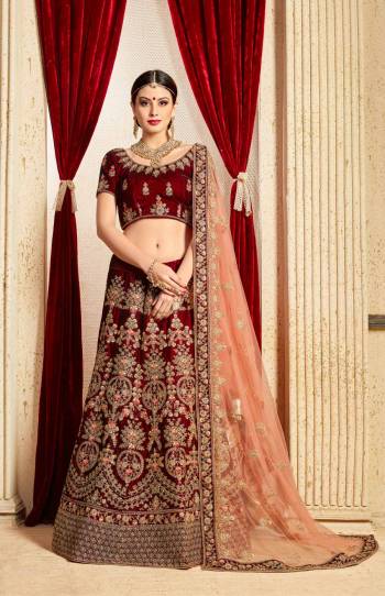 Get Ready For Your D-day With This Heavy Designer Bridal Lehenga choli In Maroon Color Paired With Contrasting Peach Colored Dupatta. This Velvet Based Lehenga And Choli Are Beautified With Heavy Jari And Resham Embroidery With Stone Work. Its Soft Net Dupatta Can Be Drape As Per It Is Suitable To You. Its Fabric Also Ensures Superb Comfort Throughout The Gala And Earn You Lots Of Compliments From Onlookers. Buy Now.