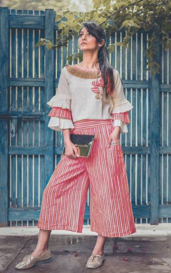 Pink linning khadi calf length pant with two big outer pocket packed with jute lace Paired With  off white pagoda sleeves top embellished jute lace at the neck line and hangging teassel