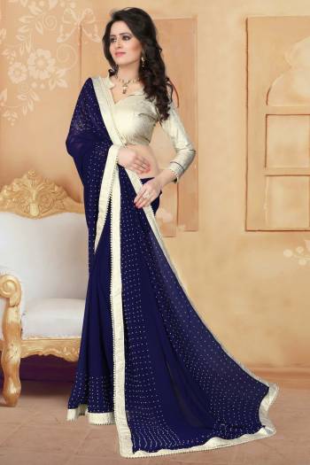 Grab This Elegant Looking Designer Saree For Your Semi-Casual Or Even Party Wear. This Saree Gives An Elegant And Simple Look Which Is Fabricated On Georgette. This Saree Is In Navy Blue Color Paired With Cream Colored Blouse. Buy This Saree Now.