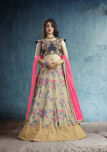 New And Unique Designer Lehenga Choli Is Here In Navy Blue Colored Blouse Paired With Beige Colored Lehenga And Fuschia Pink Colored Dupatta. Its Blouse Is Fabricated On Art Silk Paired With Muslin Silk Lehenga And Chiffon Dupatta. It Has Very Pretty Floral Prints Over The Lehenga Paired With Embroidered Blouse.