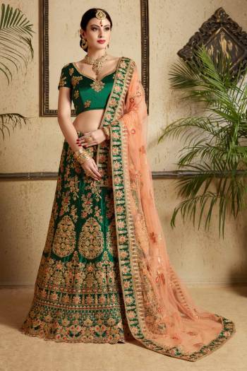 Catch All The Limelight Wearing This Heavy Designer Lehenga Choli In Pine Green Color Paired With Contrasting Peach Colored Dupatta. This Lehenga Choli Is Satin Fabricated Paired With Net Dupatta. It Has Heavy Jari And Resham Work All Over The Lehenga. Buy Now.