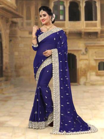 For A Festive Look, Grab This Beautiful Saree In Navy Blue Color Paired With Navy Blue Colored Blouse. This Saree And Blouse Are Georgette Based Beautified with Jari Embroidery And Moti Work Which IS Making This Saree Heavy. 