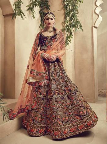 Another Attractive And Heavy Looking Designer Lehenga Choli Is Here In Wine Color Paired With Contrasting Peach Colored Dupatta. Its Blouse And Lehenga Are Velvet Fabricated Paired With Net Fabricated Dupatta. Buy this Lehenga Choli Now.