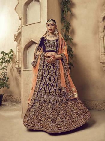 Another Attractive And Heavy Looking Designer Lehenga Choli Is Here In Wine Color Paired With Contrasting Peach Colored Dupatta. Its Blouse And Lehenga Are Velvet Fabricated Paired With Net Fabricated Dupatta. Buy this Lehenga Choli Now.