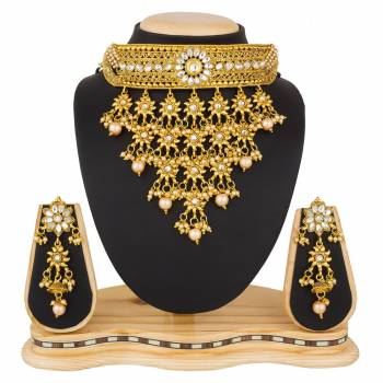 Grab This Beautiful And Attractive Looking Heavy Choker Necklace Set In Golden Color Paired With Heavy Earrings Set. This Set Is Beautified With Stone And Moti Work. It Can Be Paired With Any Colored Traditional Attire. Buy Now.