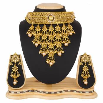 Grab This Beautiful And Attractive Looking Heavy Choker Necklace Set In Golden Color Paired With Heavy Earrings Set. This Set Is Beautified With Stone And Moti Work. It Can Be Paired With Any Colored Traditional Attire. Buy Now.