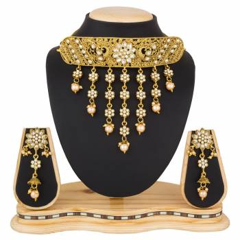 Grab This Beautiful And Attractive Looking Heavy Choker Necklace Set In Golden Color Paired With Heavy Earrings Set. This Set Is Beautified With Stone And Moti Work. It Can Be Paired With Any Colored Traditional Attire. Buy Now.