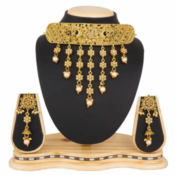 Grab This Beautiful And Attractive Looking Heavy Choker Necklace Set In Golden Color Paired With Heavy Earrings Set. This Set Is Beautified With Stone And Moti Work. It Can Be Paired With Any Colored Traditional Attire. Buy Now.