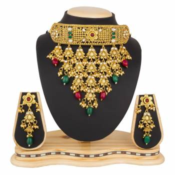 Grab This Beautiful And Attractive Looking Heavy Choker Necklace Set In Golden Color Paired With Heavy Earrings Set. This Set Is Beautified With Stone And Moti Work. It Can Be Paired With Any Colored Traditional Attire. Buy Now.