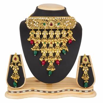 Grab This Beautiful And Attractive Looking Heavy Choker Necklace Set In Golden Color Paired With Heavy Earrings Set. This Set Is Beautified With Stone And Moti Work. It Can Be Paired With Any Colored Traditional Attire. Buy Now.