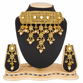 Grab This Beautiful And Attractive Looking Heavy Choker Necklace Set In Golden Color Paired With Heavy Earrings Set. This Set Is Beautified With Stone And Moti Work. It Can Be Paired With Any Colored Traditional Attire. Buy Now.