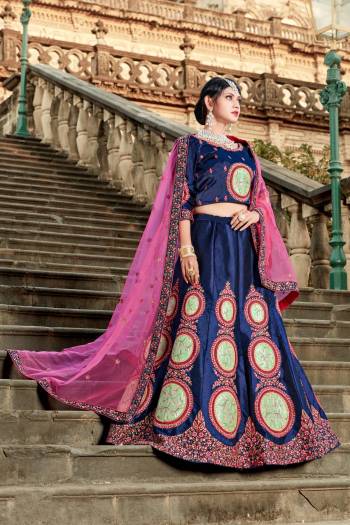 Enhance Your Personality In This Heavy Designer Lehenga Choli In Navy Blue Color Paired With Contrasting Dark Pink Colored Dupatta. Its Blouse And Lehenga Are Satin Based Paired With Net Fabricated Dupatta. 