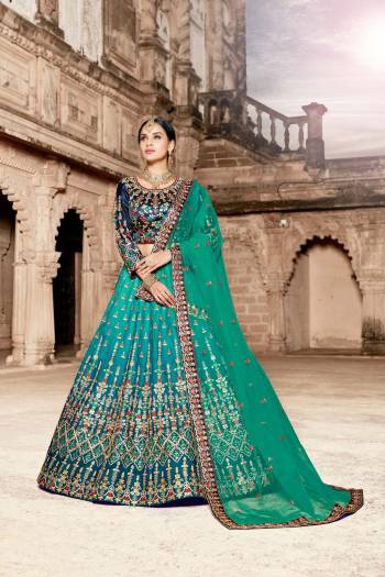 Go With The Cool Color Pallete Wearing This Heavy Designer Lehenga Choli In Navy Blue Colored Blouse Paired With Sea Green Colored Lehenga And dupatta. Its Blouse And Lehenga Are Satin Based Paired With Net Fabricated Dupatta. 