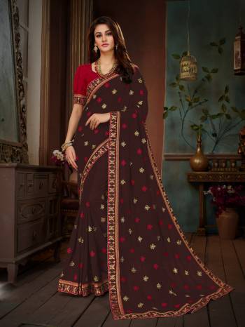 Add This Beautiful Designer Saree To Your Wardrobe In Brown Color Paired With Contrasting Red Colored Blouse. This Saree And Blouse Are Silk based Beautified With Embroidery All Over. This Saree Is Suitable For Party Or Any Festive Wear.