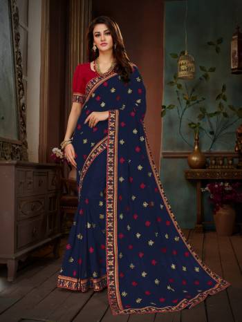 Add This Beautiful Designer Saree To Your Wardrobe In Navy Blue Color Paired With Contrasting Red Colored Blouse. This Saree And Blouse Are Silk based Beautified With Embroidery All Over. This Saree Is Suitable For Party Or Any Festive Wear.