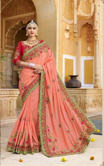 Here Is A Very Pretty Shade And Combination With This Designer Saree In Dark Peach Color Paired With Contrasting Red Colored Blouse. This Saree And Blouse Are Silk Fabricated Beautified With Heavy Embroidery. 