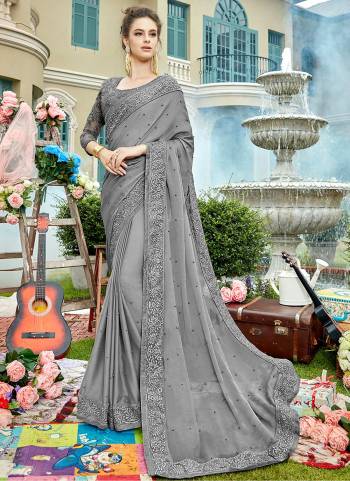 Flaunt Your Rich And Elegant Taste Wearing This Lovely Grey Colored Saree Paired With Grey Colored Blouse. This Saree Is Chiffon Based Paired With Net And Art Silk Blouse. Both Are Beautified With Heavy Embroidery.