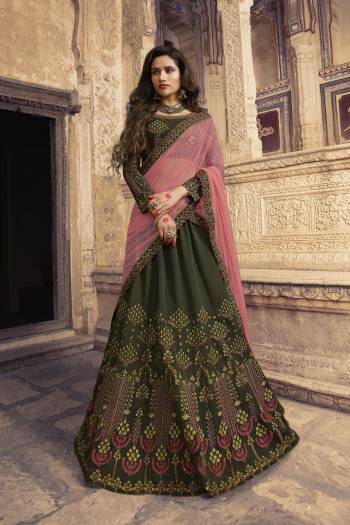 You Will Definitely Earn Lots Of Compliments With This Lovely Color Pallet,  Grab This Heavy Designer Lehenga Choli In Dark Olive Green Color Paired With contrasting Pink Colored Dupatta. It Is Soft Silk Based Which Is Soft Towards Skin and Easy To Carry All Day Long. 