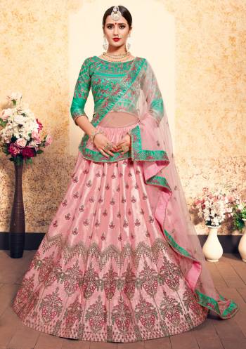 This Wedding Season, Be The Most Attractive Wearing This Heavy Designer Lehenga Choli In Sea Green Colored Blouse Paired With Contrasting Light Pink Colored Lehenga And Dupatta. Its Blouse And Lehenga Are Satin Based Paired With Net Fabricated Dupatta. 