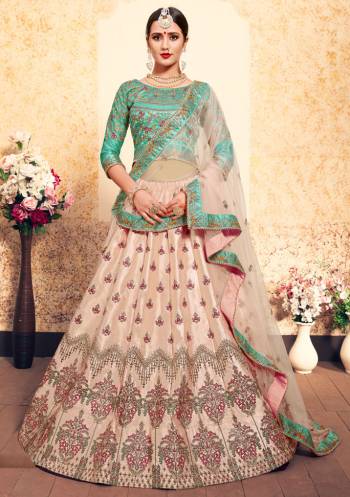 This Wedding Season, Be The Most Attractive Wearing This Heavy Designer Lehenga Choli In Sea Green Colored Blouse Paired With Contrasting Light Peach Colored Lehenga And Dupatta. Its Blouse And Lehenga Are Satin Based Paired With Net Fabricated Dupatta. 