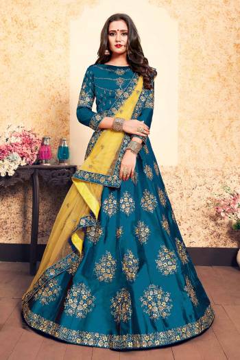 You Will Definitely Earn Lots Of Compliments Wearing This Designer Lehenga Choli In Blue Color Paired With Contrasting Yellow Colored Dupatta. Its Blouse And Lehenga Are Satin Based Paired With Net Fabricated. Buy Now.