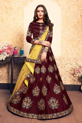 You Will Definitely Earn Lots Of Compliments Wearing This Designer Lehenga Choli In Maroon Color Paired With Contrasting Yellow Colored Dupatta. Its Blouse And Lehenga Are Satin Based Paired With Net Fabricated. Buy Now.