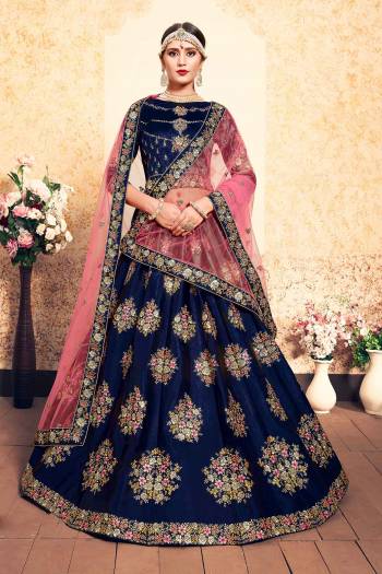 You Will Definitely Earn Lots Of Compliments Wearing This Designer Lehenga Choli In Blue Color Paired With Contrasting Pink Colored Dupatta. Its Blouse And Lehenga Are Satin Based Paired With Net Fabricated. Buy Now.