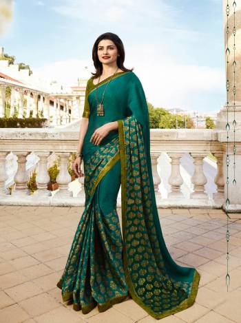 Add This New Shade To Your Wardrobe With This Printed Saree In Peacock Blue Color Paired With Contrasting Olive Green Colored Blouse. This Saree Is Georgette Based Paired With Art Silk Fabricated Blouse. 