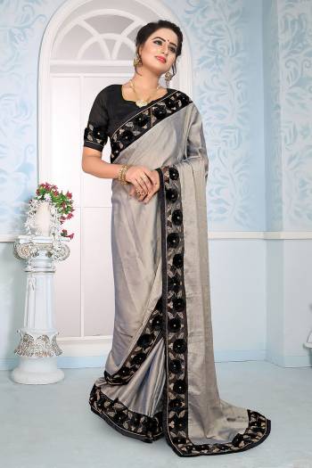 Flaunt Your Rich And Elegant Look Wearing This Designer Saree In Grey Color Paired With Black Colored Blouse. This Saree Is Fabricated On Satin Silk Paired With Art Silk Fabricated Blouse. It Has Fancy 3D Flower With Coding Embroidery. 