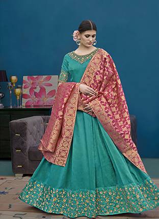 For This Wedding And Festive Season, Grab This Designer Floor Length Suit In Turquoise Blue Color Paired With Contrasting Pink Colored Dupatta. Its Top Is Fabricated On Art Silk Paired With Santoon Bottom And Banarasi Jacquard Dupatta. Buy Now.