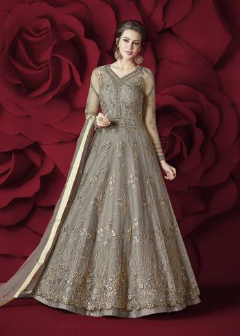 Flaunt Your Rich and Elegant Taste Wearing This Designer Floor Length Suit In Grey Colored Top Paired With Grey Colored Bottom And Dupatta. Its Top Is Fabricated On Net Paired With Silk Bottom And Net Dupatta. Its Rich and Elegant Embroidery Will Earn Your Lots Of Compliments From Onlookers.