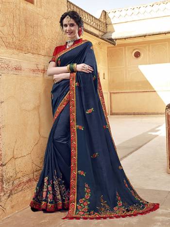 Enhance Your Personality Wearing This Designer Saree In Navy Blue Color Paired With Contrasting Red Colored Blouse, This Saree And Blouse Are Fabricated On Art Silk Beautified With Contrasting Embroidery Giving It An Attractive Look.