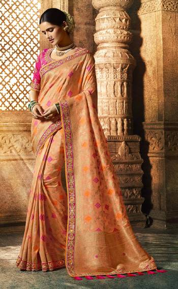 A Must Have Shade In Every Womens Wardrobe Is Here With This Beautiful Saree In Peach Color Paired With Contrasting Dark Pink Colored Blouse. Its Pretty Color Pallete And Rich Silk Fabric Will Earn You Lots Of Compliments From Onlookers. 