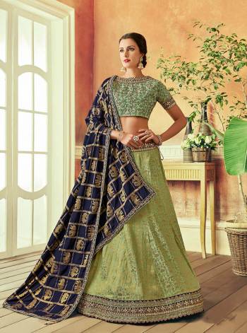 Harness the age-old love for traditional attires with a dash of modern hues and contrasts in this green and blue lehenga fabricated in lavish silks and look appealing. 