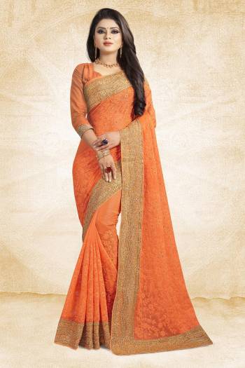 Get Ready For The Upcoming Wedding Season With This Heavy Designer Saree In Orange Color Paired With Orange Colored Blouse. This Saree Is Fabricated On Chiffon Beautified With Heavy Embroidery And Heavy Embroidered Lace Border Paired With Art Silk Fabricated Blouse. 