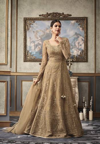 Flaunt Your Rich And Elegant Taste Wearing This Heavy Designer Floor Length Suit In Beige Color Paired With Beige Colored Bottom And Dupatta. Its Heavy Embroidered Top Is Net Based Paired With Art Silk Bottom and Net Fabricated Dupatta. Buy This Rich Designer Suit Now.