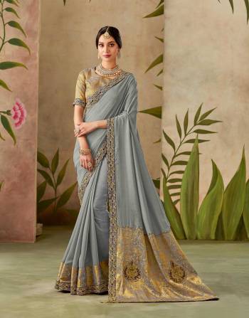 Look remarkably sophisticated in this grey-hued saree adorned with handwork details and soft weaves. Add a belt to the drape for a modern appeal. 