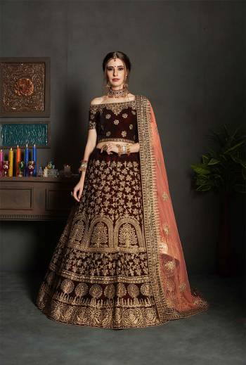 Here Is A Perfect Bridal Look For You In The Running Treand With This Heavy designer Lehenga Choli In Maroon Color Paired With Contrasting Peach Colored Dupatta. This Lehenga Choli Is Velvet Based Paired With Net Fabricated Dupatta.Its Fabric Also Ensures Superb Comfort Throughout The Gala