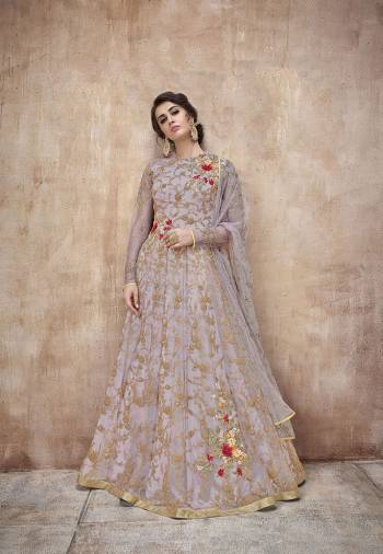 New Shade Is Here To Add Into Your Wardrobe. This Pretty Mauve Colored Designer Floor Length Suit Is A Shade Of Purple And Grey. It Is Paired With Mauve Colored Bottom And Dupatta. Its Heavy Embroidred Top And Dupatta Are Fabricated On Net Paired With Satin Silk Bottom. Buy This Rich Designer Suit Now.