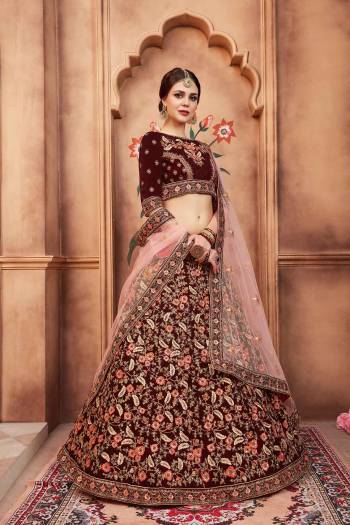 Catch All The Limelight At The Next Wedding You Attend Wearing This Designer Lehenga Choli In Maroon Color Paired With Contrasting Baby Pink Colored Dupatta. Its Blouse And Lehenga Are Fabricated Velvet Paired With Net Fabricated Dupatta. 