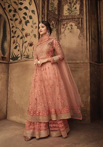 Look Beautiful In This Designer Sharara Suit In Very Pretty Peach Color. This Pretty Suit Is Net Fabricated Beautified With Attractive Tone To Tone Work .