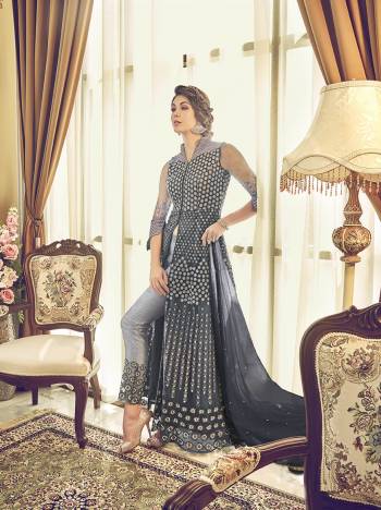 Get Ready For The Upcoming Festive And Wedding Season With This Designer Sharara Suit In Grey Color. This Suit Is Net Based Beautified With Heavy Embroidery All Over It. Buy Now.