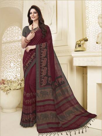 For A Royal Look, Grab This Elephant Printed Saree In Maroon Color Paired With Contrasting Grey Colored Blouse. This Saree And Blouse Are Silk Based Beautified With Elephant Prints Broad Border. 