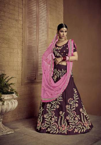 Catch All The Limelight Wearing This Heavy Designer Lehenga Choli In Dark Wine Color Paired With Contrasting Pink Colored Dupatta. Its Blouse And Lehenga Are Satin Silk Fabricated Paired With Net Fabricated Dupatta. 