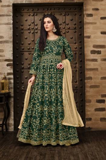 Here Is A Beautiful Heavy Designer Floor Length Suit In Dark Green Color Paired With Beige Colored Dupatta. Its Heavy Embroidered Floor Length Top Is Fabricated On Tafeta Silk Paired With Santoon Bottom And Net Fabricated Dupatta. Buy Now.