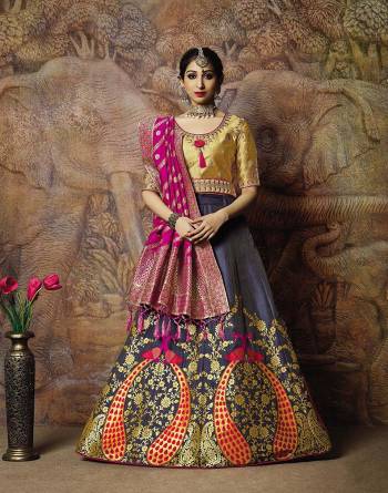 Adorn A Proper Traditional Look Wearing This Heavy Designer Lehenga Choli In Golden Colored Blouse Paired With Dark Grey Colored Lehenga And Rani Pink Colored Dupatta. This Lehenga And Blouse Are Fabricated On Jacquard Silk Paired With Brocade Fabricated Blouse. 