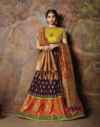 Adorn A Proper Traditional Look Wearing This Heavy Designer Lehenga Choli In Yellow Colored Blouse Paired With Wine Colored Lehenga And Rust Orange Colored Dupatta. This Lehenga And Blouse Are Fabricated On Jacquard Silk Paired With Brocade Fabricated Blouse. 