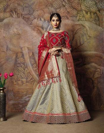 You Will Definitely Earn Lots Of Compliments In This Rich Silk Based Designer Lehenga Choli. Its Blouse Is In Red Color Paired With Grey Colored Lehenga And Red Colored Dupatta. It Is Beautified With Bold Weave And Subtle Embroidery Over The Blouse. Buy This Silk Based Lehenga Choli Now.