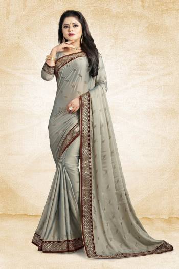 Flaunt Your Rich And Elegant Taste Wearing This Designer Saree In Grey Color Paired With Grey Colored Blouse. This Saree Is Fabricated On Satin Georgette Paired With Art Silk Fabricated Blouse. It Is Beautified With Heavy Embroidered Lace Border And Stone Work Butti Pattern Over The Saree. 