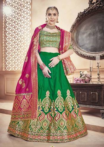 For A Proper Traditional Look, Grab This Designer Lehenga Choli In Green Color Paired With Contrasting Dark Pink Colored Dupatta. It Is Fabricated On Banarasi Art Silk Beautified With Attractive Weave. 